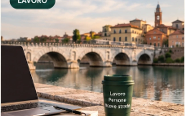 Postazione di lavoro con tazza e laptop affacciata sul Ponte di Tiberio a Rimini
